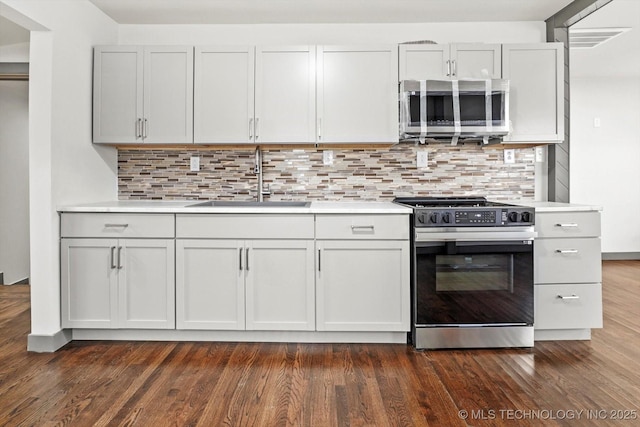 kitchen with decorative backsplash, sink, appliances with stainless steel finishes, and dark hardwood / wood-style floors