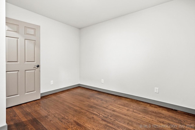 spare room with dark hardwood / wood-style flooring