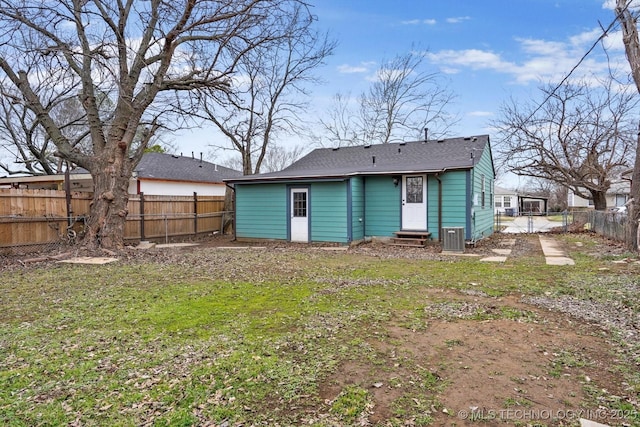 rear view of property with a lawn and central air condition unit