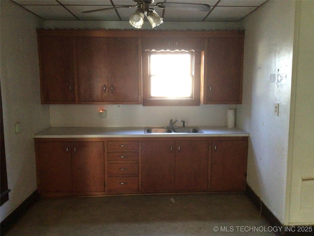 kitchen with ceiling fan, a drop ceiling, and sink