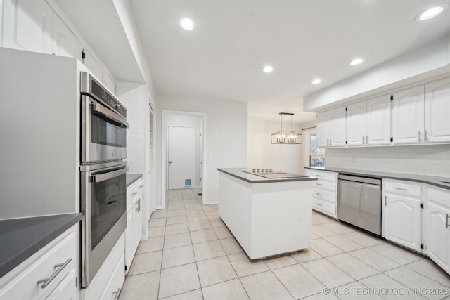 kitchen with stainless steel appliances, white cabinets, hanging light fixtures, and a center island