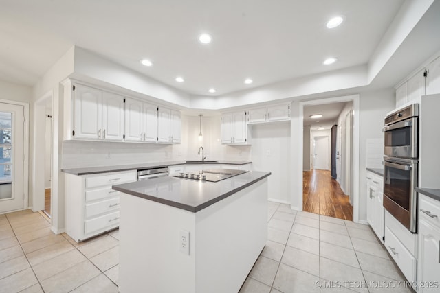 kitchen featuring light tile patterned floors, white cabinetry, a center island, double oven, and dishwashing machine