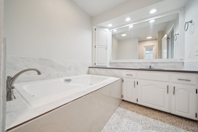 bathroom featuring a washtub, vaulted ceiling, vanity, and tile patterned flooring