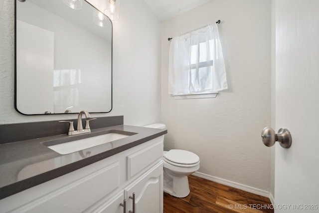 bathroom with hardwood / wood-style floors, toilet, and vanity