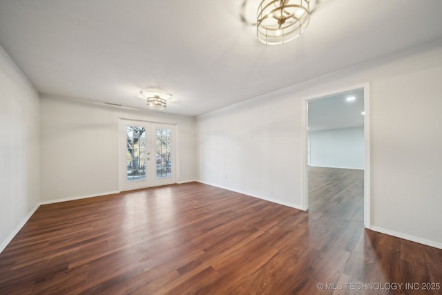 unfurnished room with french doors, dark wood-type flooring, and a chandelier