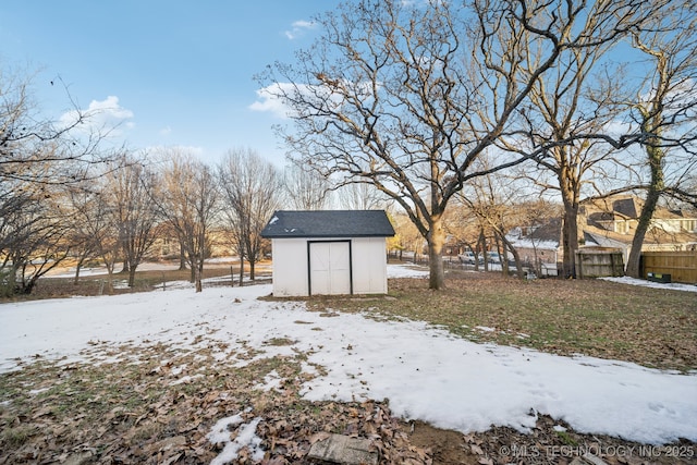 yard layered in snow featuring a shed