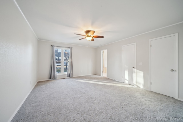 empty room with ceiling fan, light carpet, and crown molding