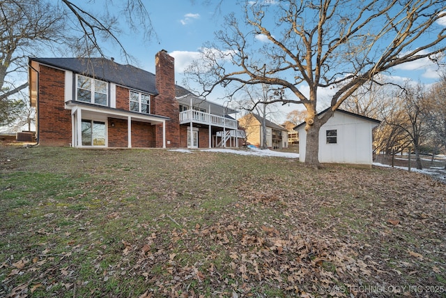 back of property featuring a lawn and an outdoor structure