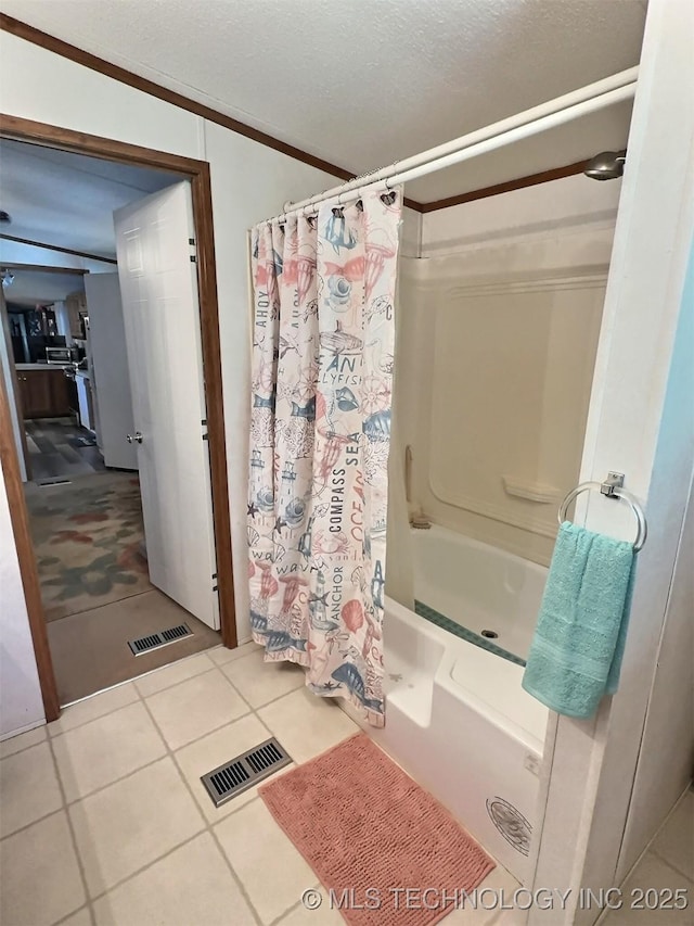 bathroom with tile patterned floors and shower / bath combo with shower curtain