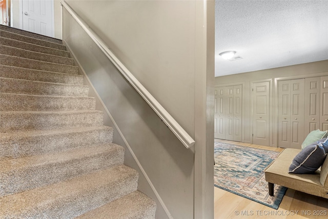 stairway with a textured ceiling