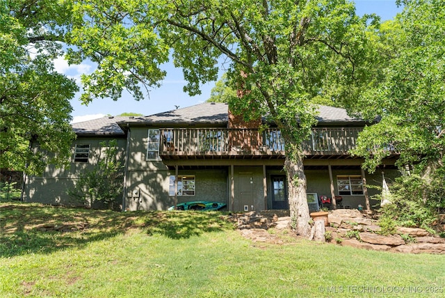 rear view of property with a wooden deck and a yard