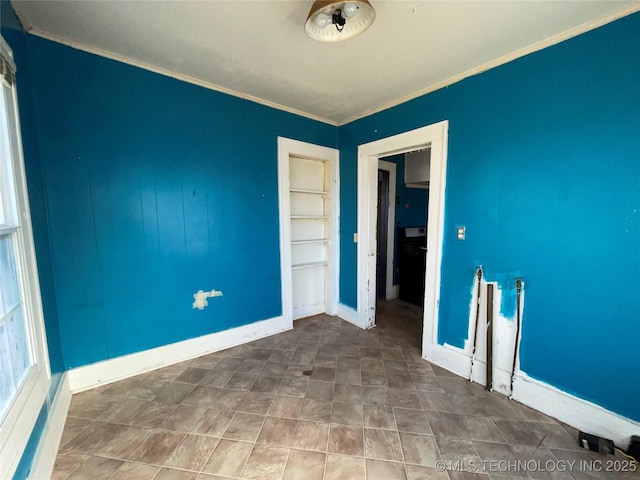 spare room featuring crown molding and built in shelves