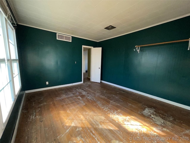 spare room featuring dark wood-type flooring and ornamental molding