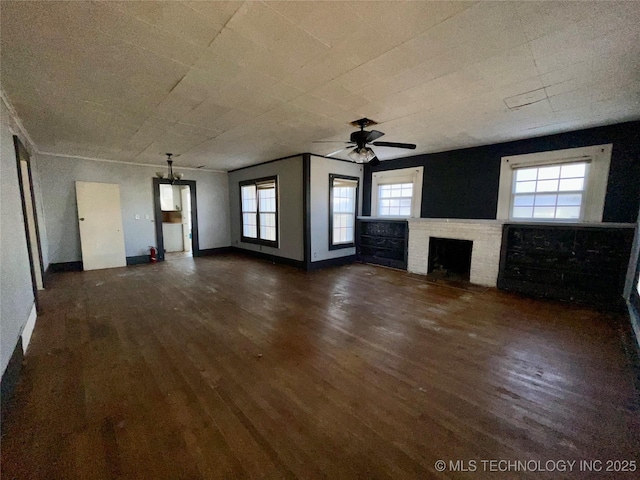 unfurnished living room with a healthy amount of sunlight, a brick fireplace, dark wood-type flooring, and ceiling fan