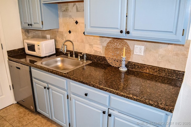 kitchen featuring light tile patterned floors, white microwave, a sink, backsplash, and dishwasher