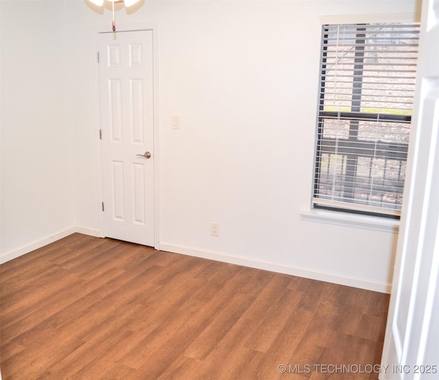 empty room featuring baseboards and wood finished floors