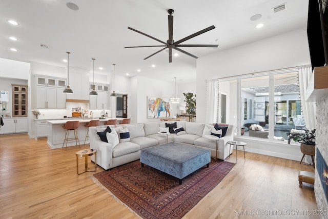 living room with recessed lighting, a ceiling fan, light wood finished floors, and visible vents