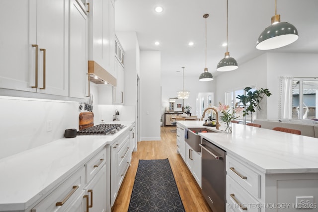 kitchen with white cabinets, pendant lighting, appliances with stainless steel finishes, and a center island with sink