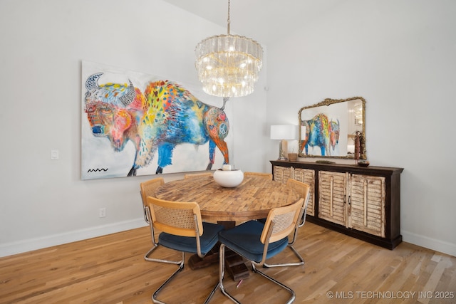 dining area with baseboards, a chandelier, and light wood-style floors