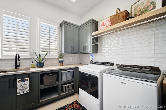 laundry area with a sink, light tile patterned floors, cabinet space, and washer and dryer