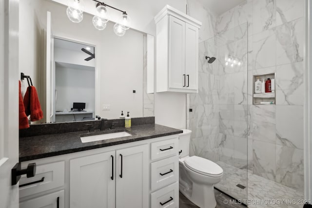 bathroom with vanity, a marble finish shower, and toilet