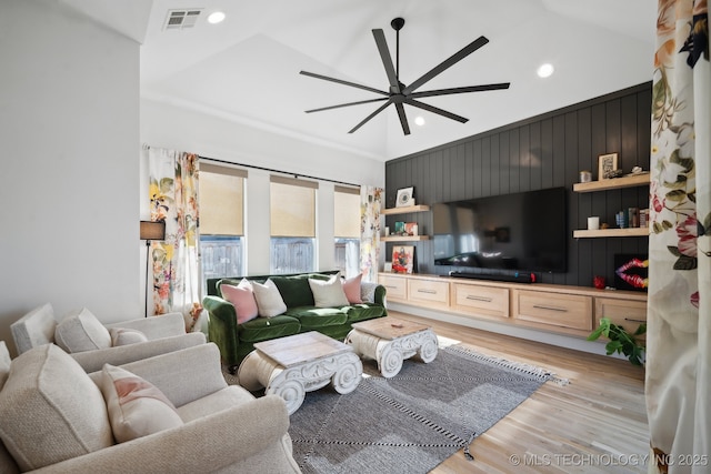 living room featuring ceiling fan, lofted ceiling, and light hardwood / wood-style floors