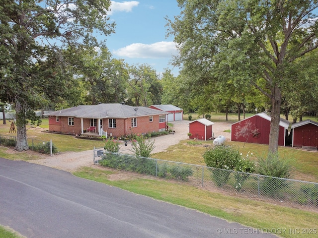 view of front of home with a garage, an outdoor structure, and a front yard