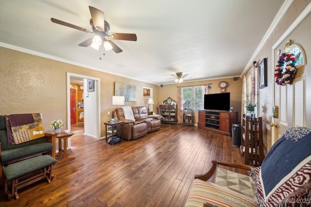 living room with ornamental molding, dark wood-type flooring, and ceiling fan