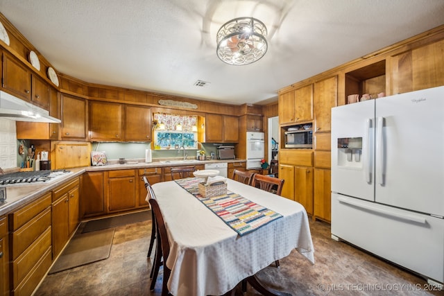 kitchen with a kitchen island, appliances with stainless steel finishes, sink, and a textured ceiling