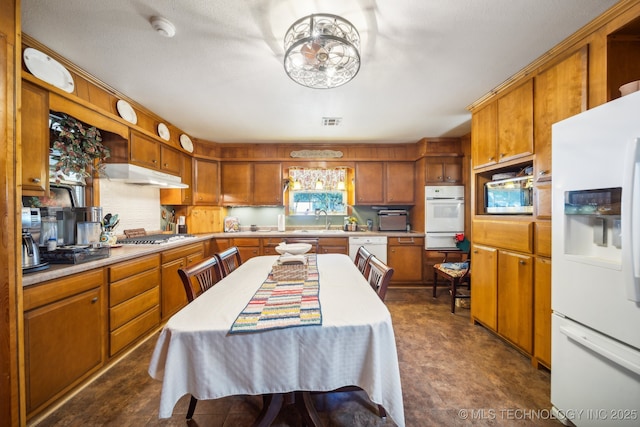 kitchen with white appliances, sink, and a textured ceiling