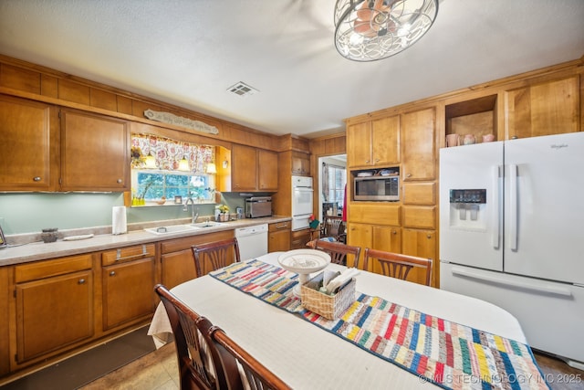 kitchen featuring sink, white appliances, plenty of natural light, and light tile patterned floors