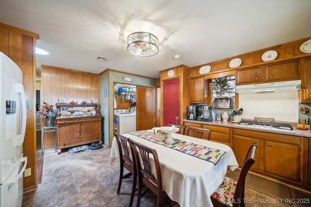 kitchen featuring washer / clothes dryer, carpet, stainless steel gas cooktop, and white fridge with ice dispenser