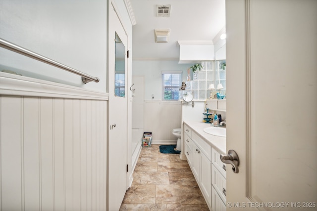 bathroom with vanity, crown molding, and toilet