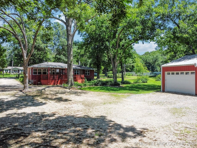 exterior space with a garage, an outbuilding, a porch, and a front yard