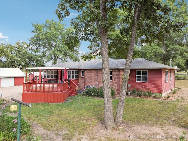 view of front of property with a garage, an outdoor structure, a deck, and a front yard