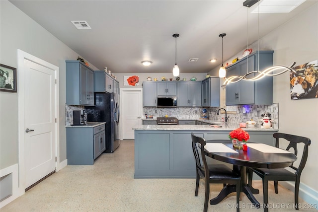 kitchen with backsplash, decorative light fixtures, stainless steel appliances, and kitchen peninsula