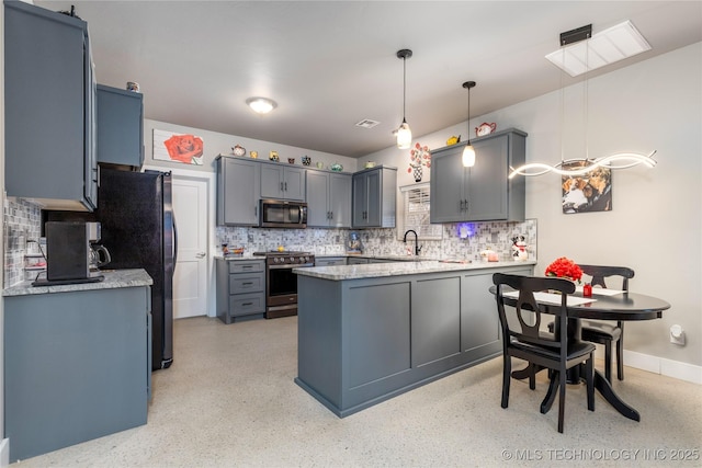 kitchen with pendant lighting, stainless steel appliances, sink, and tasteful backsplash