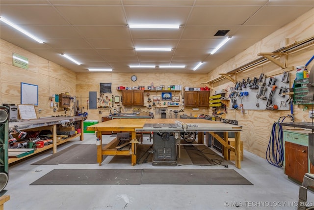 interior space featuring a paneled ceiling, a workshop area, and concrete floors