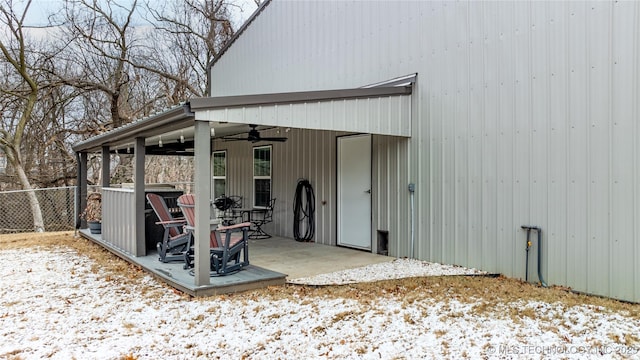 snow covered house with ceiling fan and a patio area