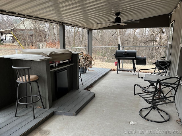 exterior space featuring ceiling fan, grilling area, and exterior bar