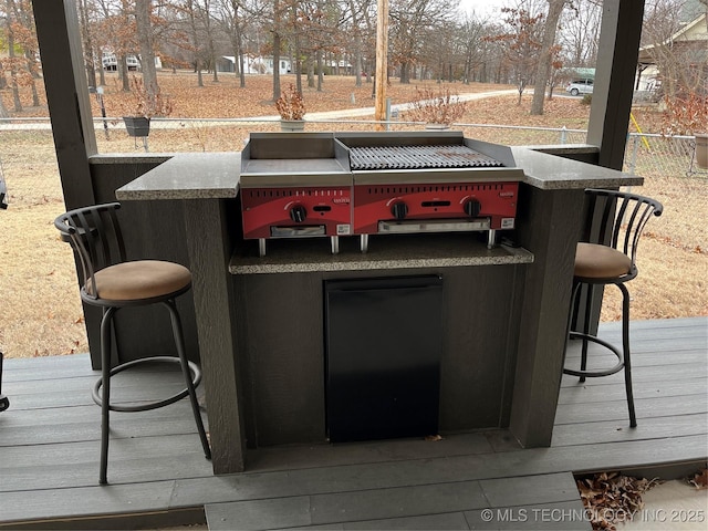 wooden terrace with exterior bar and a grill