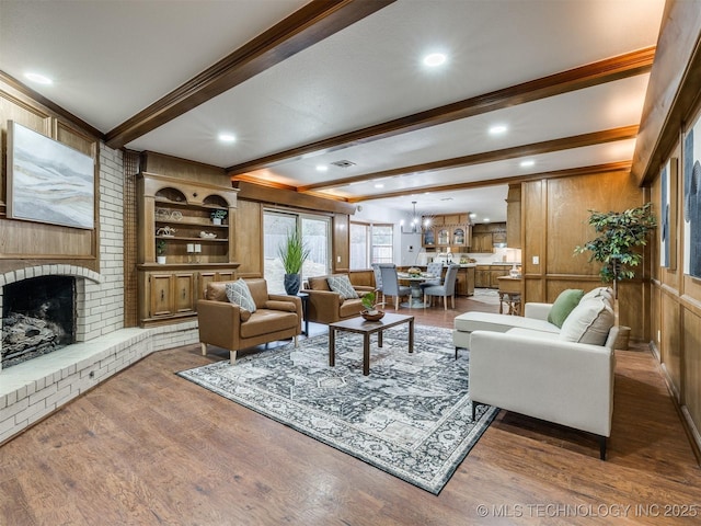 living room featuring a fireplace, wood walls, beam ceiling, and dark hardwood / wood-style flooring