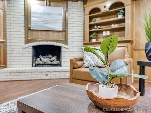 interior space featuring hardwood / wood-style flooring, built in shelves, and a fireplace