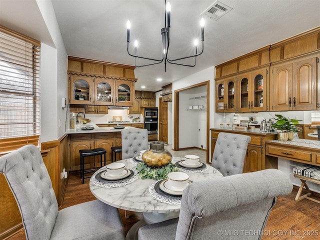 dining room with sink, dark hardwood / wood-style flooring, and a chandelier