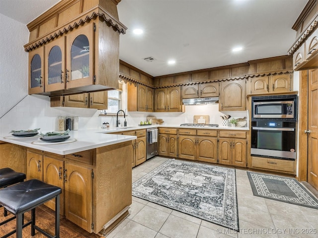 kitchen featuring appliances with stainless steel finishes, a kitchen breakfast bar, sink, kitchen peninsula, and light tile patterned flooring