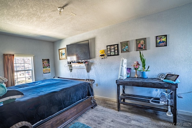 bedroom with hardwood / wood-style flooring and a textured ceiling