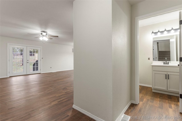 interior space with hardwood / wood-style flooring, vanity, ceiling fan, and french doors