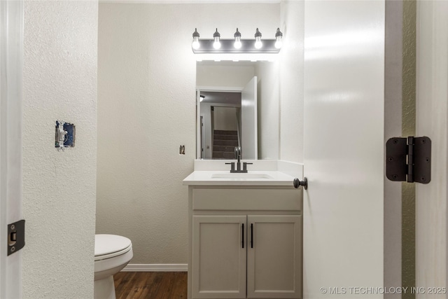 bathroom featuring hardwood / wood-style flooring, toilet, and vanity