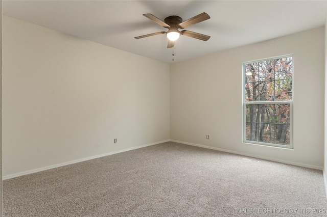 carpeted spare room featuring ceiling fan