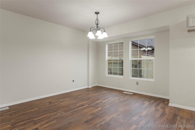 unfurnished room featuring a chandelier and dark hardwood / wood-style floors